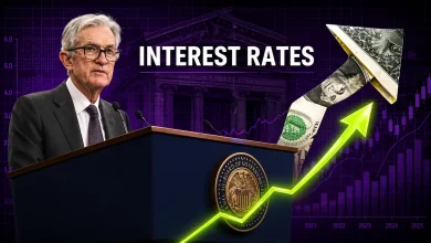 Federal Reserve Chair Jerome Powell speaking at a podium with the words "INTEREST RATES" and an upward-trending arrow made of US dollar bills against a purple market chart.