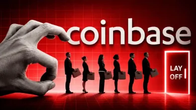 A giant hand flicking a line of office workers carrying boxes toward a glowing red door labeled "LAY OFF" in front of a large Coinbase logo.
