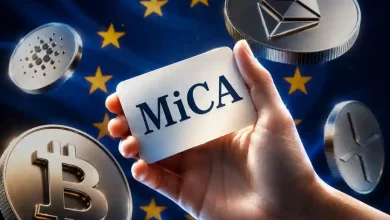 A hand holding a white card labeled "MiCA" surrounded by floating silver cryptocurrency coins against the European Union flag.