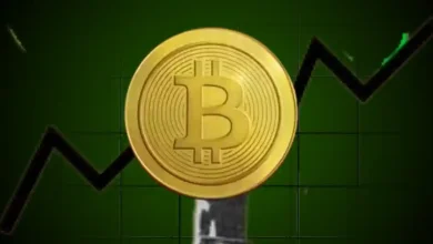 A gold Bitcoin token in front of a rising multi-colored line graph.