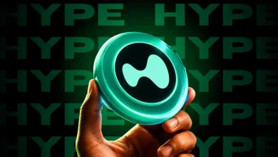 A hand holding a glowing teal HYPE token icon against a dark green backdrop.