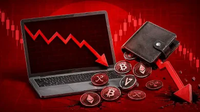 Red downward trend line over laptop with crypto wallet spilling coins.