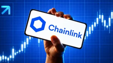 Hand holding smartphone displaying Chainlink logo over bullish chart.