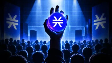 Hand holding a glowing blue Stacks STX coin under a spotlight before a crowd