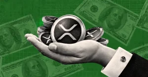 Open hand holding silver XRP coins over background of 100 dollar bills